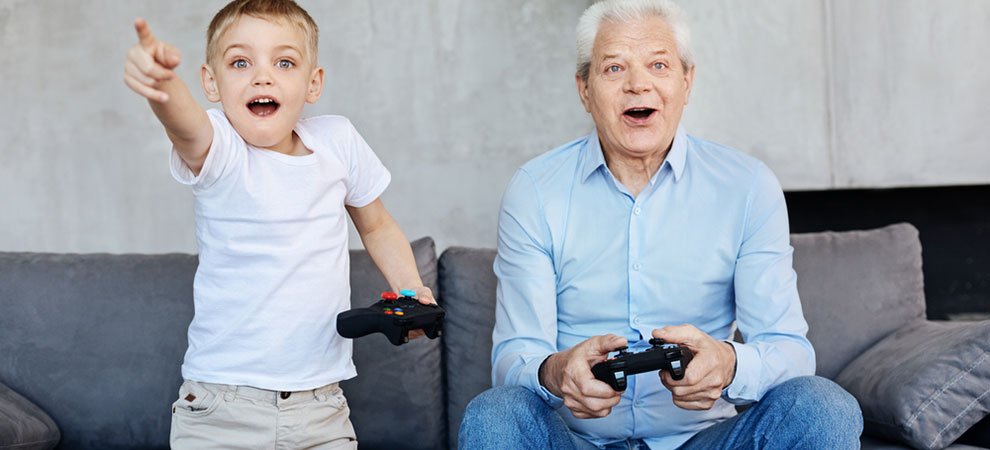 An older man and a child playing video games. An example of what older gamers look like.